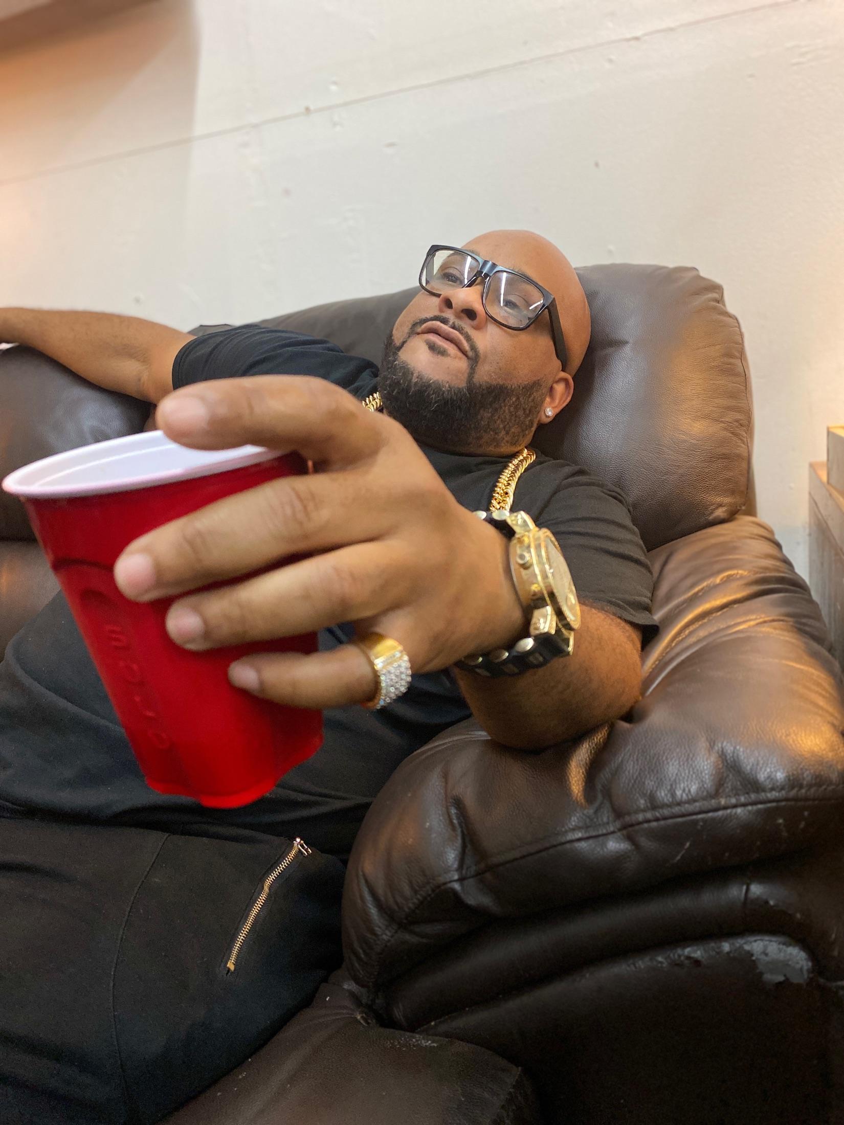 Boogie Taylor extending a red cup toward the camera